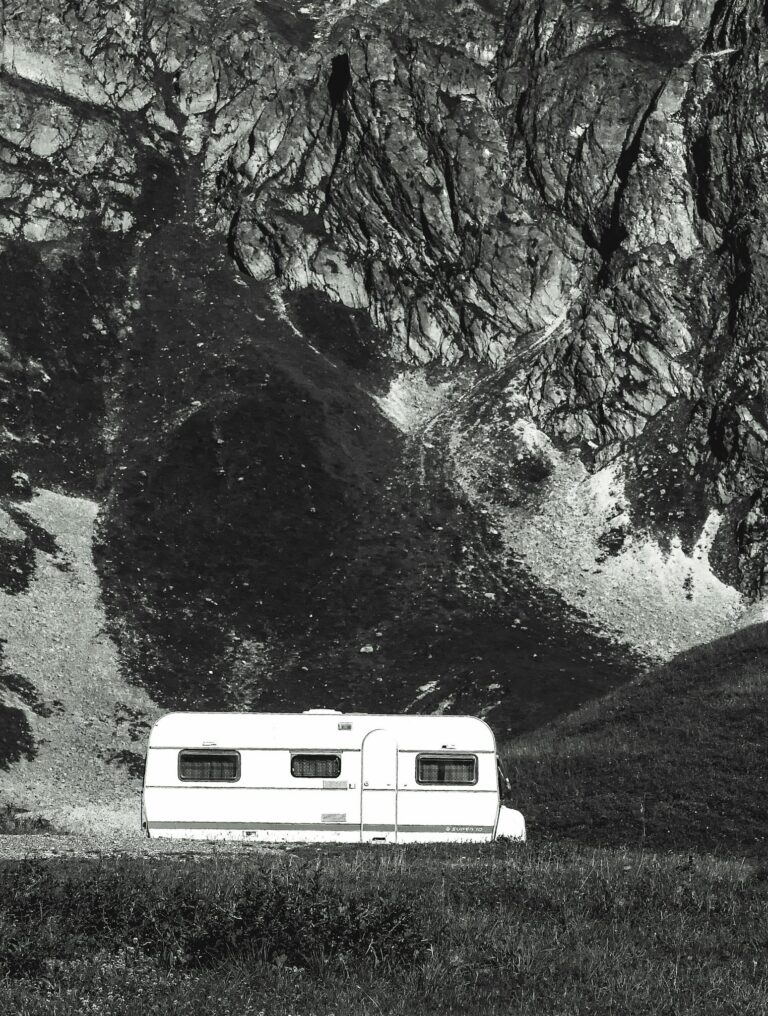 A caravan parked against the majestic mountain backdrop of La Plagne Tarentaise in France, capturing serene outdoor vibes.