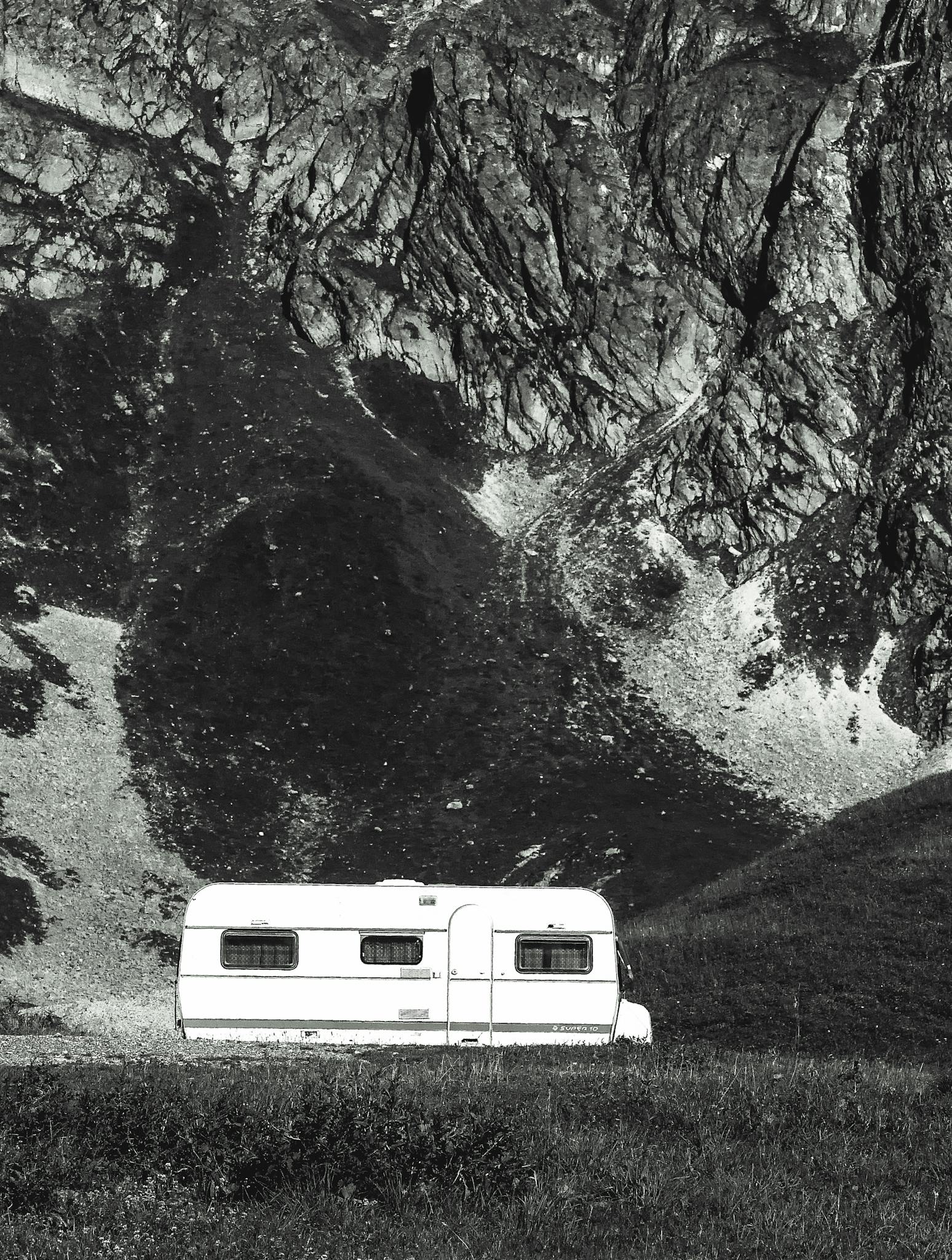 A caravan parked against the majestic mountain backdrop of La Plagne Tarentaise in France, capturing serene outdoor vibes.